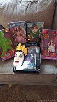 Photo showing all five figures in their original packaging: Grinch, Barbie (2), Ken, Wicked Queen, Cindy Lou Who, boxes with visible dents and creases.