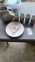 Full view of the pitcher, four numbered glasses, and Millennium plate on table