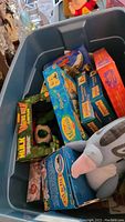 Top view of blue tote showing boxed Hulk figure and other boxed toy sets, plus plush dog toy