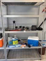 Straight front view of a metal shelving unit loaded with various items, demonstrating the shelving structure and condition.