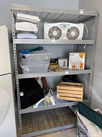 Front view of assembled metal shelving unit with items placed on shelves to show scale and structure.