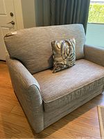 Frontal view of loveseat with one throw pillow
