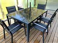 Overall view of rectangular table, six chairs, umbrella and base on deck