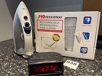 Photo showing Proctor Silex iron, Professional rechargeable hair clipper box, and Cardinal clock radio.