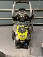 Full front view of unit showing frame, wheels, handle, hose and gun