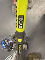 Close-up of Ryobi Easy Edge trimmer shaft showing branding and control button.