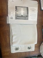 Photo showing the curtain panels partially unfolded with the package label stating Exclusive Home, including curtain image and identifying details.