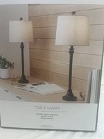 Original product box displaying two bronze finish table lamps with beige shades, showing on/off rotary switches.
