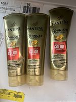 Three gold-colored Pantene Pro-V 3 Minute Miracle Radiant Color Shine Conditioner bottles with red label, 8 fl oz each.