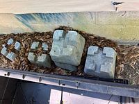 Six gray concrete deck blocks, two showing top recessed holders and some damage on one block