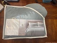 Photo showing the duvet cover set in original packaging with brand and product line Nate Berkus Project Q, reversible dot woven design, full/queen size, 100% cotton, machine washable.