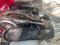 Top view of the under desk exercise bike showing the two foot pedals and flywheel housing.