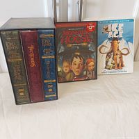 The Lord of the Rings motion picture trilogy extended DVD editions in slipcase alongside Monster House DVD and Ice Age 9-disc special edition DVD cases on a white surface.