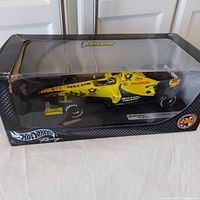 Front-angle view of the 1:18 scale Jordan F1 car model in original box showing yellow car and box front damage.