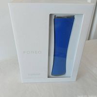 Front view of sealed Foreo Espada acne blue light pen in white box with visible blue device.