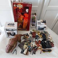Overall lot view including Queen Amidala doll in box, Mandalorian mug and socks box, The Mandalorian Child heat change mug box, juggling balls box, and multiple loose Star Wars figures and accessories.