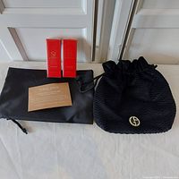 Photo showing the black Giorgio Armani travel bag with a dust cover, two boxes of Giorgio Armani Si Passione Eau de Parfum travel sprays, and a card from Giorgio Armani.