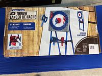 Box front showing axe throw target image, components list, and storage feature.