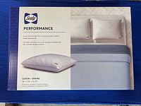 Front of original packaging showing Sealy Performance Queen size pillow with dimensions and image of pillow on bed with bedding.