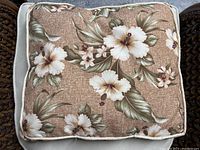 Top view showing floral design on beige background with white and cream flowers and green leaves.