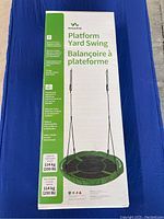 Photo of boxed VivaActive Platform Yard Swing showing front with product image and description, highlighting 95cm diameter and 250 lbs weight support.