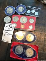 Top-down overview of all coins in lot, grouped: Canadian Confederation coins, US proof set, individual Canadian 5 cents, and 1943 US coin set.