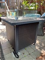 Side view showing synthetic wicker base and glass wind guard panels on top