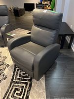 Full front angle view of grey recliner in basement setting
