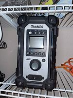Close up showing Makita work radio with digital display and control buttons.