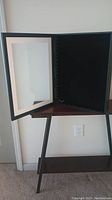 Front view of shadow box opened showing glass front and black interior.