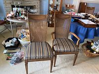 Two wood dining chairs with cane backs and striped upholstered seats, front view