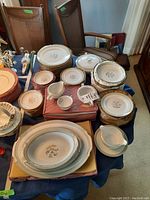 Full view of the dining set showing plates, bowls, creamer, sugar bowl, serving pot, and gravy boat with saucer arranged on table.