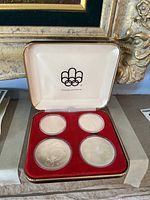 Four Montreal 1976 Olympic coins set in original red velvet collector's case with Olympic logo.