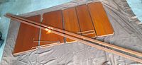 Five teak veneer shelves laid out with two long rails across