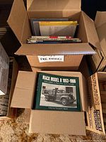Open box showing an assortment of books labeled Fire Engines and various vehicle books underneath