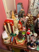 View of the entire assortment of Christmas music boxes, candle lights, figurines and decorations on a wooden dresser