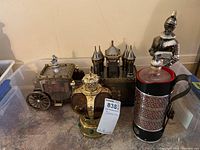Overview showing all five decanter music boxes: crown, castle, stagecoach, knight, cylindrical.