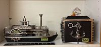 Both liquor decanters shown side by side, Natchez paddle wheeler on left and anchor themed cube on right.