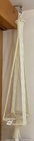 Full view of cream-colored macrame plant hanger showing the hanging loop, cords, and diamond knot pattern with clear plastic base suspended.