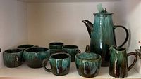 Overview photo showing entire coffee set including decanter, creamer, sugar container, five cups, and saucer server.