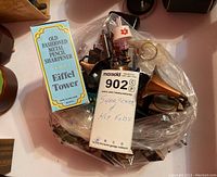 Overview of novelty pencil sharpeners and key fobs including boxed Eiffel Tower sharpener and various metal novelty designs in clear bag