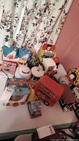 Photo showing assorted vintage musical and novelty toys including Mickey Mouse Jack in the Box, a baseball toy, a blue elephant toy, a red bus toy, and other items on a tabletop.
