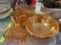 Photo showing vintage amber-colored glass pieces including 2 steins, a round bowl, oval bowl, and textured rectangular dish resembling a log.