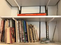 Shelf view of vintage cookbooks including a clearly visible red/orange spine book titled 'The Delicacies of Turkish Cooking'