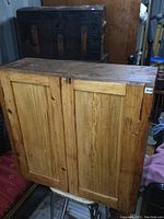 Front view of solid wood antique postal cabinet with two doors, showing natural wood grain and aged condition.
