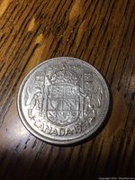 Obverse side showing Canadian Coat of Arms, denomination, and year 1957.