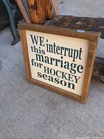 Front view of wood framed sign with text about marriage and hockey season.
