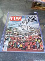 Front cover of the Life magazine showing the large group of Disney employees standing in front of Cinderella Castle with Disney characters in front, marking Disney World opening in 1971.
