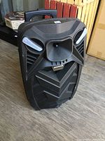 Front angled view of the black Sylvania speaker showing handle and wheel base.