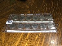 Photo of Canadian quarter collection holder with 12 specialized quarters in plastic display. Display shows months and province/territory names.
